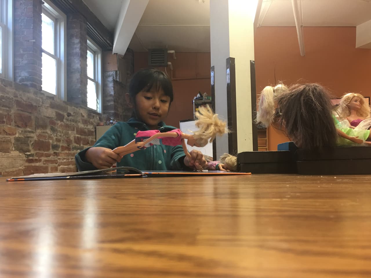 Zury, la hija más pequeña de Vizguerra, juega con sus muñecas en un salón del sótano de la congregación.