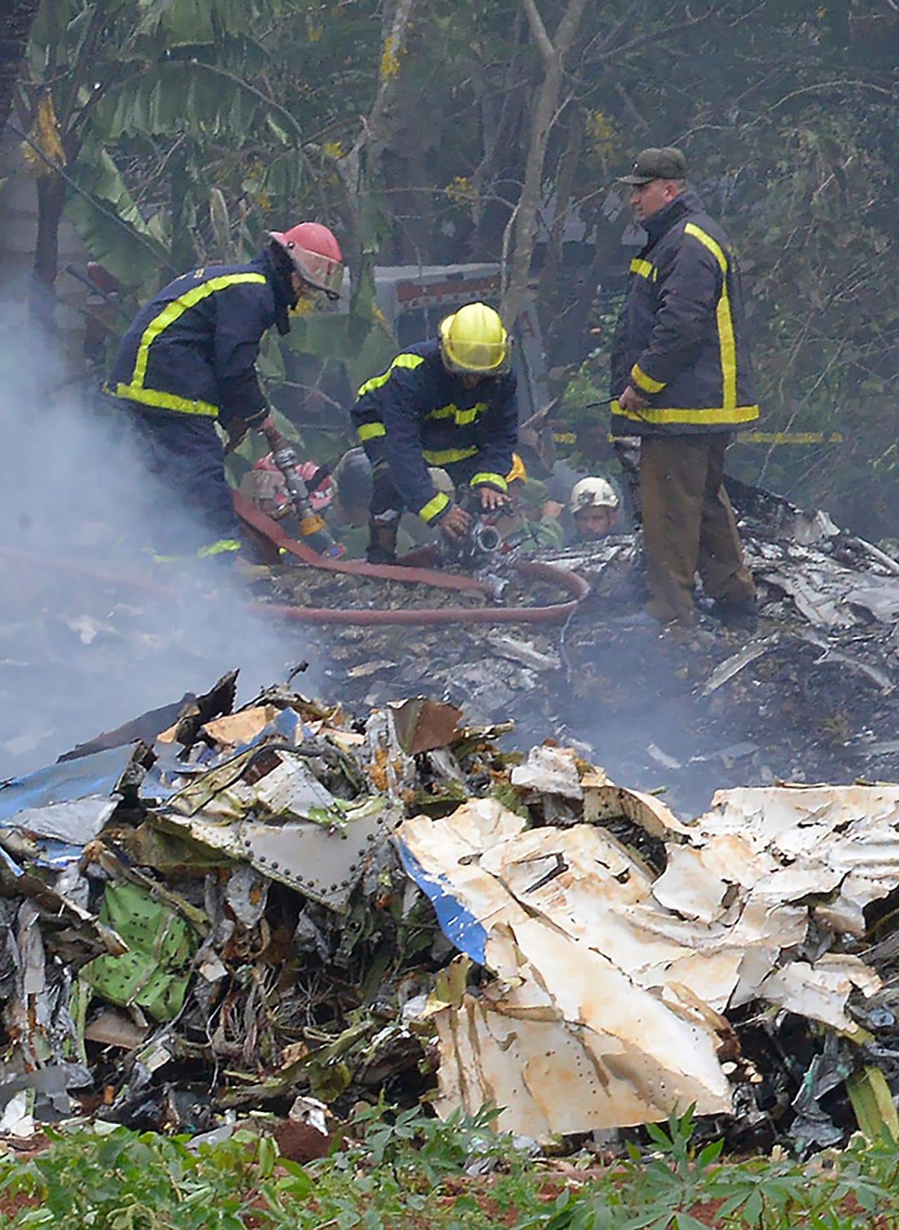 Bomberos revisan los restos de la aeronave accidentada.
<br>