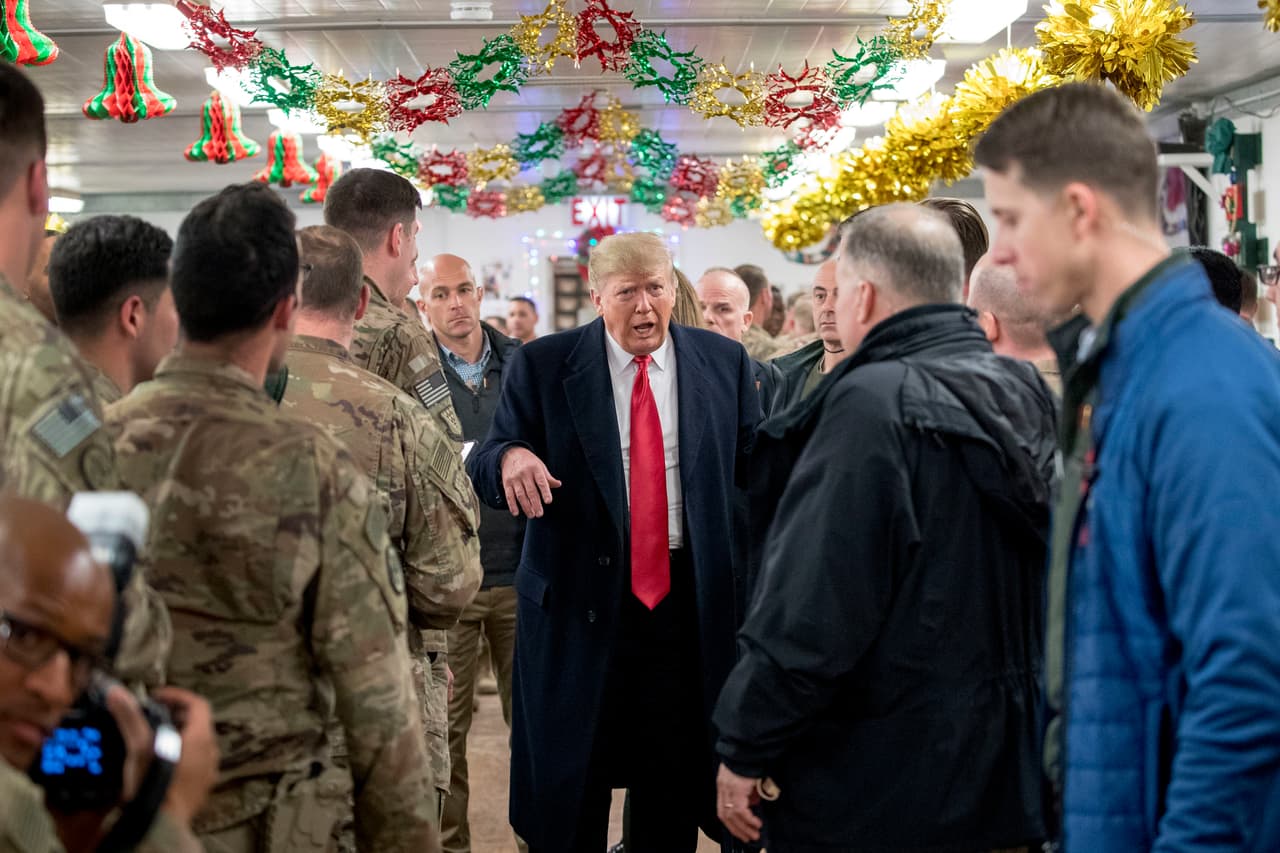 El presidente Trump visita a efectivos de las fuerzas armadas en un comedor en la base aérea de Al Asad, Irak. Trump defendió su decisión de retirar las fuerzas estadounidenses de Siria, donde han estado ayudando a combatir a los militantes del Estado Islámico