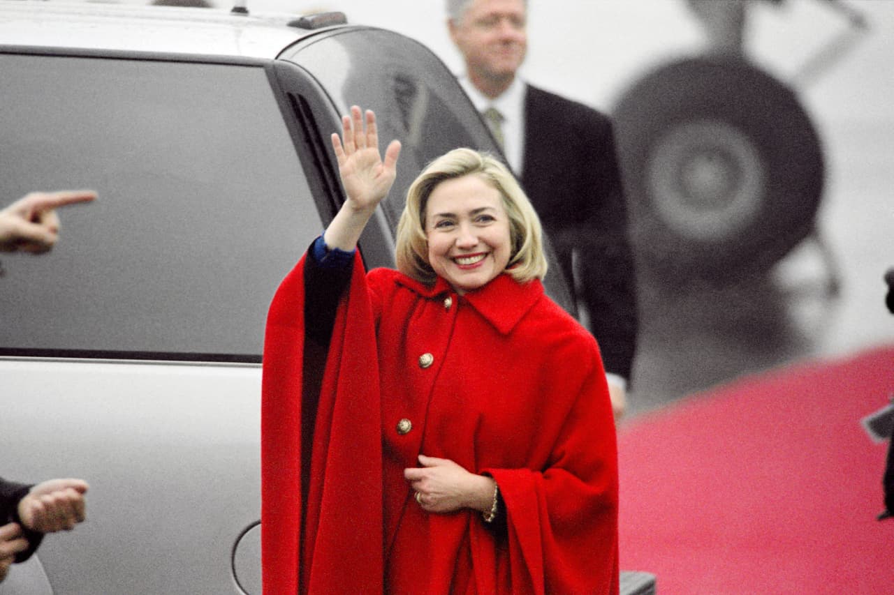 La capa de botones grandes y cuello, en especial una de color rojo como esta que usó Hillary Clinton en su viaje a Sarajevo, en 1997, es uno de esos legados noventeros que aún pervive en el armario de las señoras más mayores cuando de afrontar las estaciones frías se trata. STEPHEN JAFFE/AFP/Getty Images