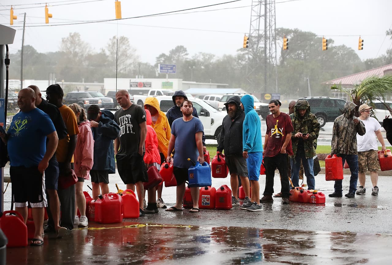 WILMINGTON, NC - SEPTEMBER 15: People wait in line to fill up their gas cans at a gas station that was damaged when Hurricane Florence hit the area, on September 15, 2018 in Wilmington, North Carolina. Hurricane Florence made landfall in North Carolina as a Category 1 storm Friday and at least five deaths have been attributed to the storm, which continues to produce heavy rain and strong winds extending out nearly 200 miles. (Photo by Mark Wilson/Getty Images)