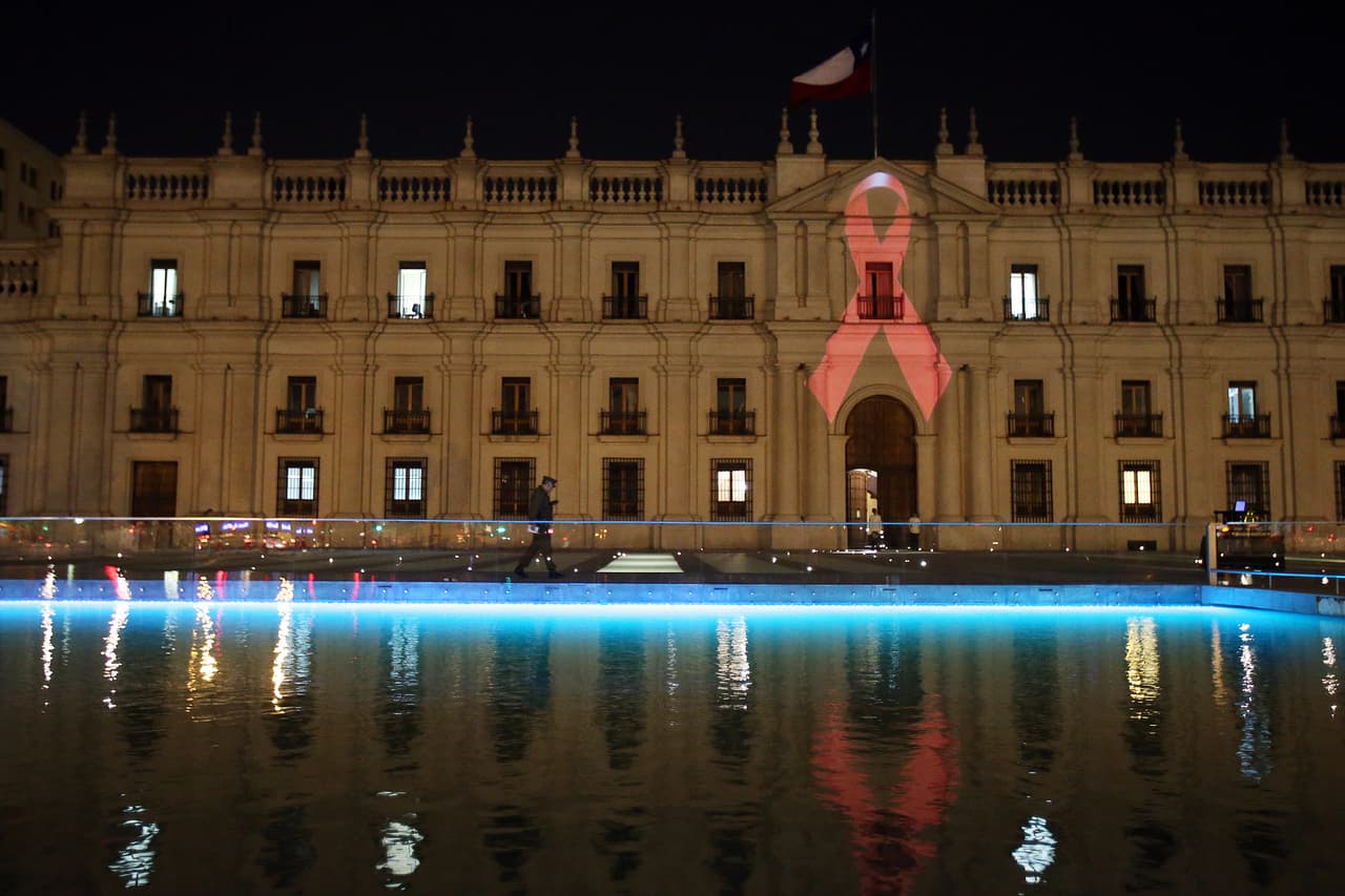 <b>Chile fue el país de Latinoamérica que más aumento su tasa de contagios durante el periodo 2010 – 2018</b>, con un incremento de 34%, seguido de un 22% en Bolivia y un 21% en Brasil y Costa Rica.
<br>La fotografía muestra el Palacio de La Moneda en la capital chilena, Santiago, iluminado con el 'Lazo de la Vida', símbolo de la lucha contra el sida.