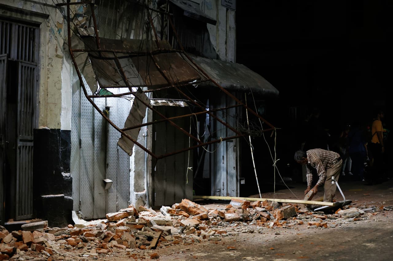 Un hombre retira escombros de un edificio dañado tras el terremoto.