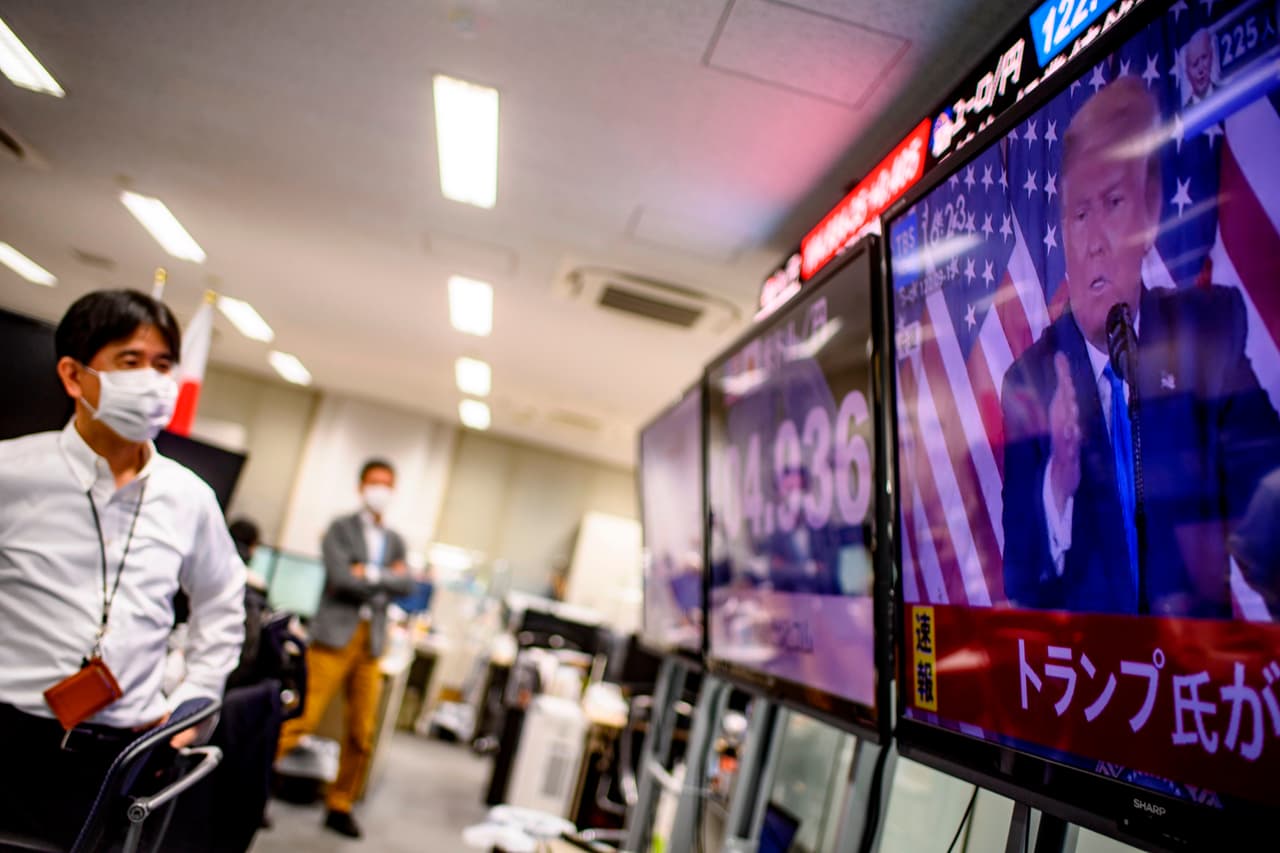 Empleados de una casa de cambio en Tokio miran el discurso de Donald Trump en la madrugada de la noche electoral. “Escucho que resolver las cosas tomará tiempo”, dijo sobre la contienda estadounidense el ministro de hacienda japonés Taro Aso. “No tengo la menor idea de cómo nos afectará”.