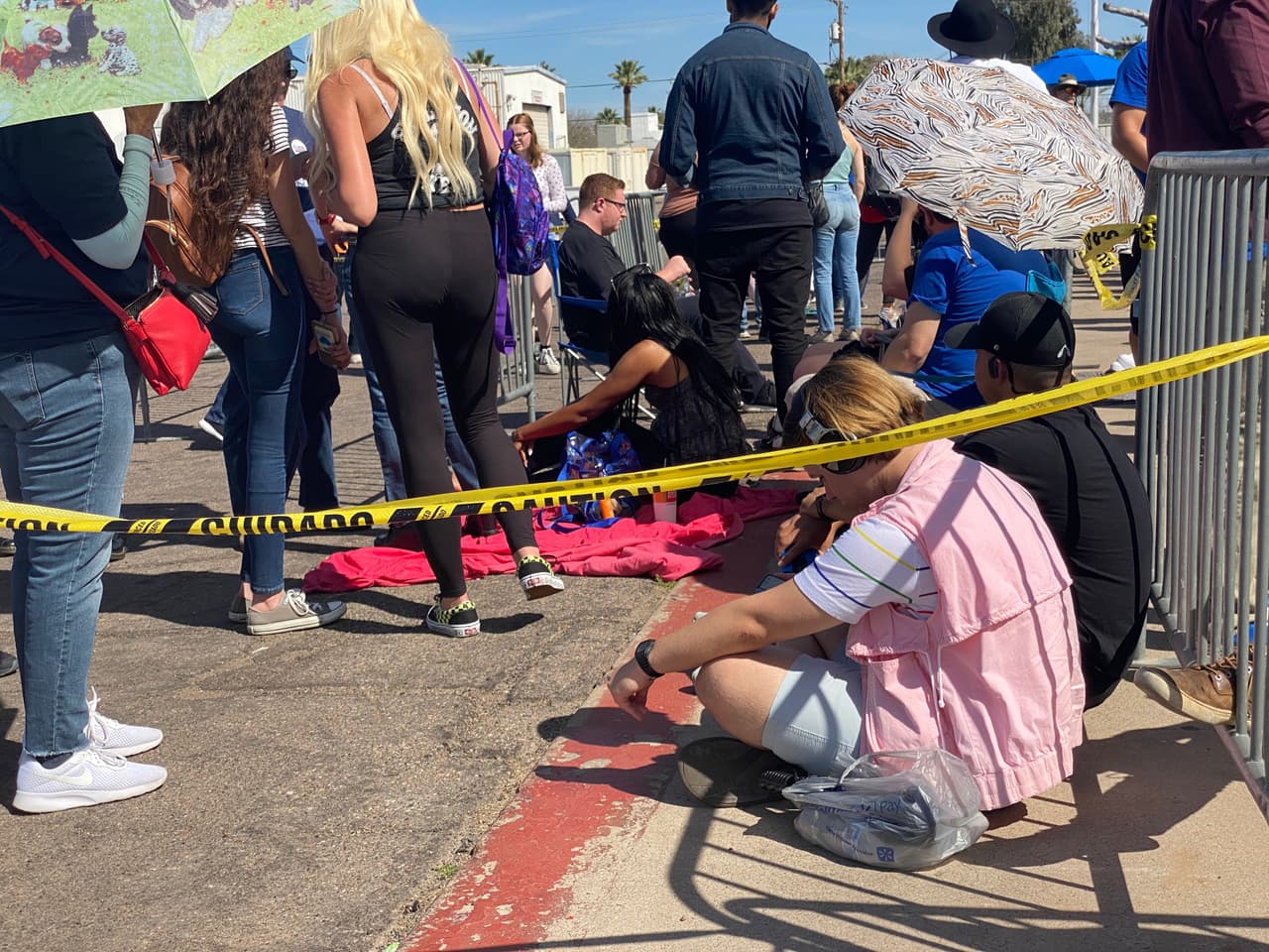 Buscando un espacio en la acera y otros con mantas, así esperan los simpatizantes de Sanders la manifestación política del candidato demócrata en Arizona.