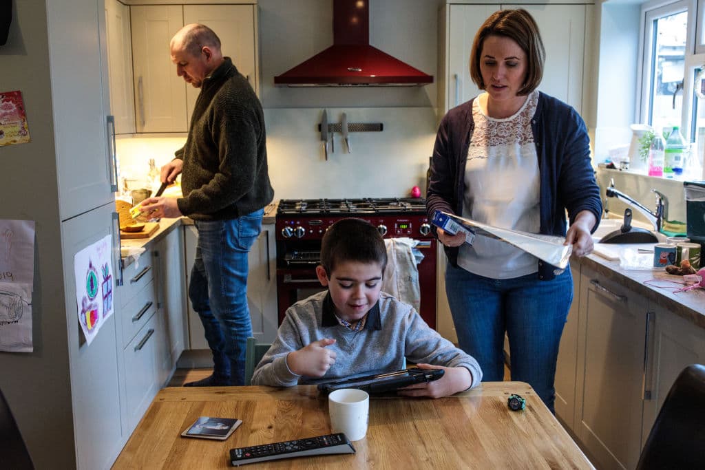 Alfie mira un video mientras sus padres Drew Dingley y Hannah Deacon preparan la comida en su casa de Kenilworth, en Inglaterra. Hannah Deacon, su madre, continúa haciendo campaña para el acceso a la marihuana medicinal después de que las directrices médicas más recientes restringieran su uso, dejando a Alfie como el único paciente del NHS con acceso al aceite de cannabis para tratar la epilepsia.