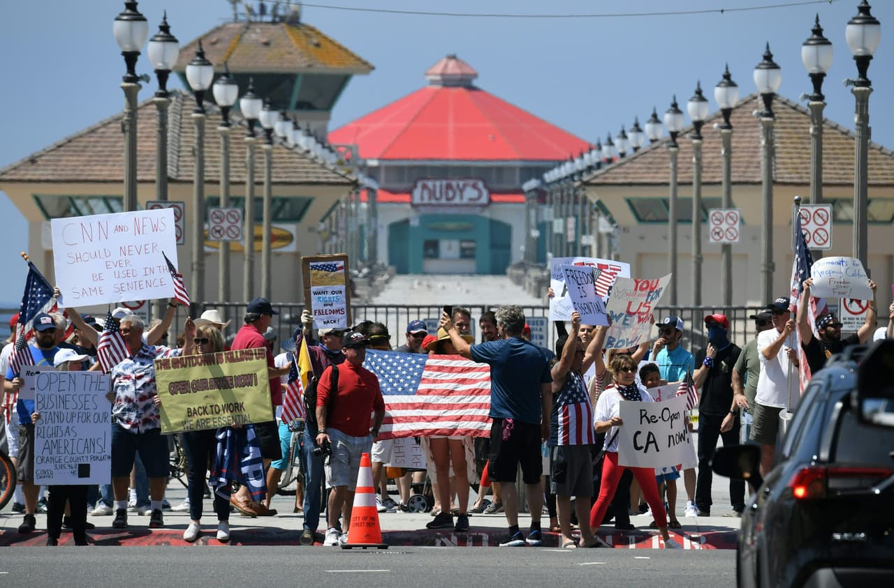 Demonstrators gather at Huntington beach to protest the state's stay-at-home order amid the coronavirus pandemic, on May 1, 2020 in California. (Photo by Robyn Beck / AFP) (Photo by ROBYN BECK/AFP via Getty Images)