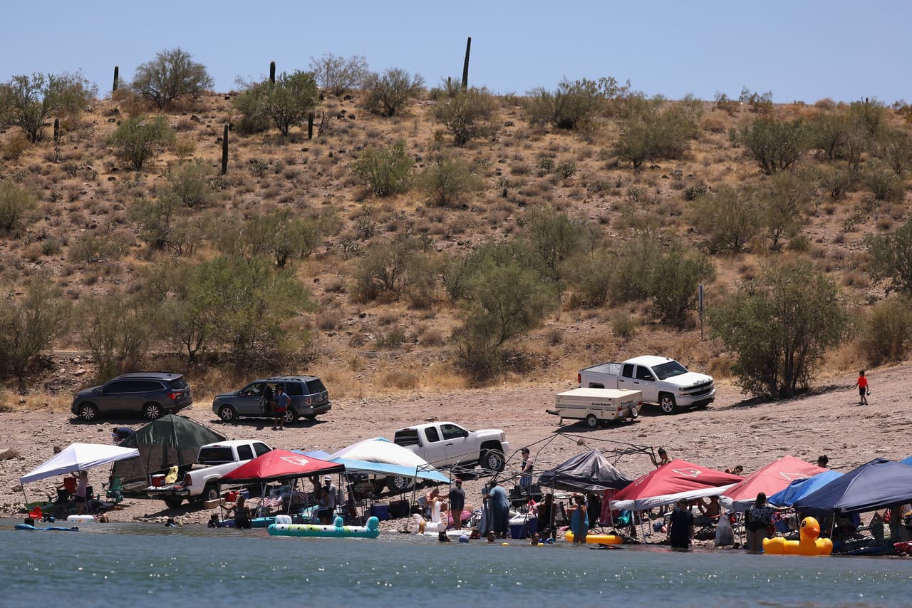 En Arizona los casos confirmados rebasaron el lunes los 100,000, y más de la mitad de esos contagios, cerca de 62,000, son personas menores de 44 años. 
<br>
<br>En la fotografía decenas de personas celebran el 4 de julio en un lago de Morristown, a unas 40 millas al norte de Phoenix.