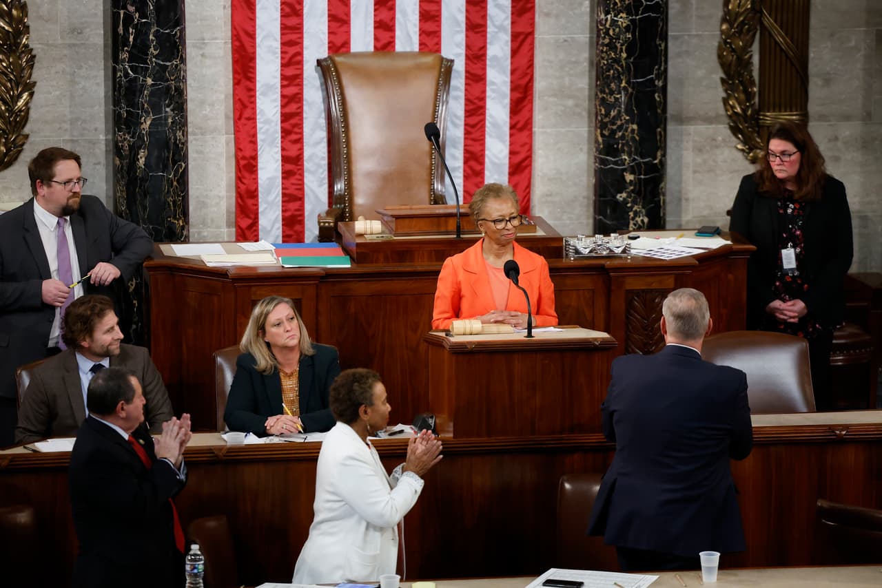 La Secretaria de la Cámara de Representantes, Cheryl Johnson, recibe una ovación de pie en la sala durante el tercer día de votación para seleccionar al Presidente de la Cámara Baja, en el Capitolio. A su espalda, se observa la silla vacía del futuro Presidente del cuerpo legislativo.
