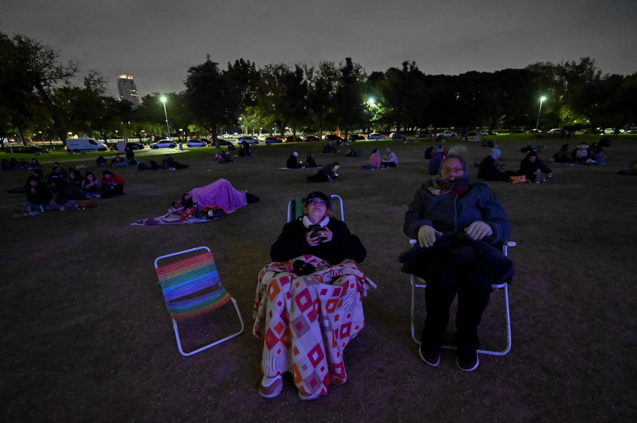 Personas mirando hacia el cielo para presenciar el eclipse lunar en Buenos Aires, Argentina.