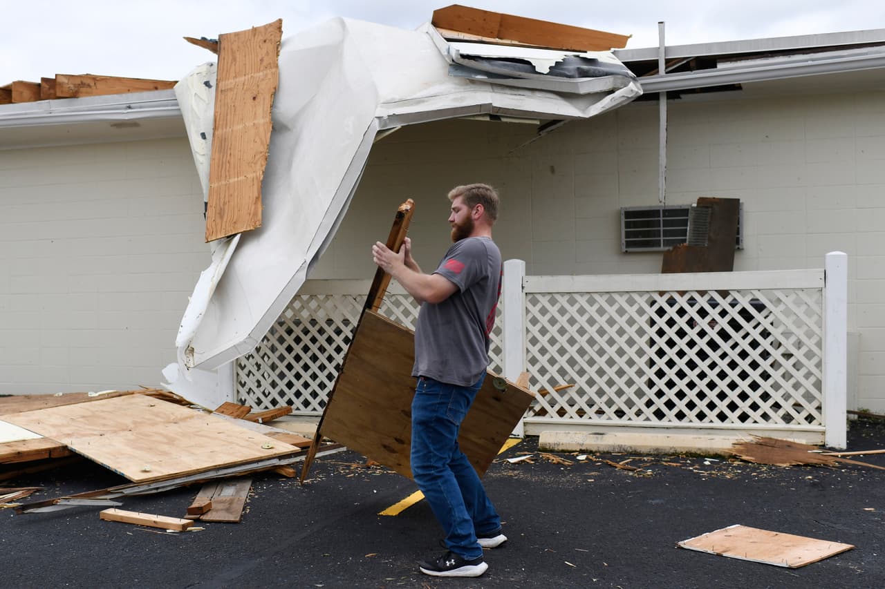 Jonathan Poston, de la funeraria Lewis, limpia los escombros dejados por la tormenta Isaias el sábado 10 de octubre de 2026 en Milton, Florida. (Foto AP/Octavio Jones)
<br>