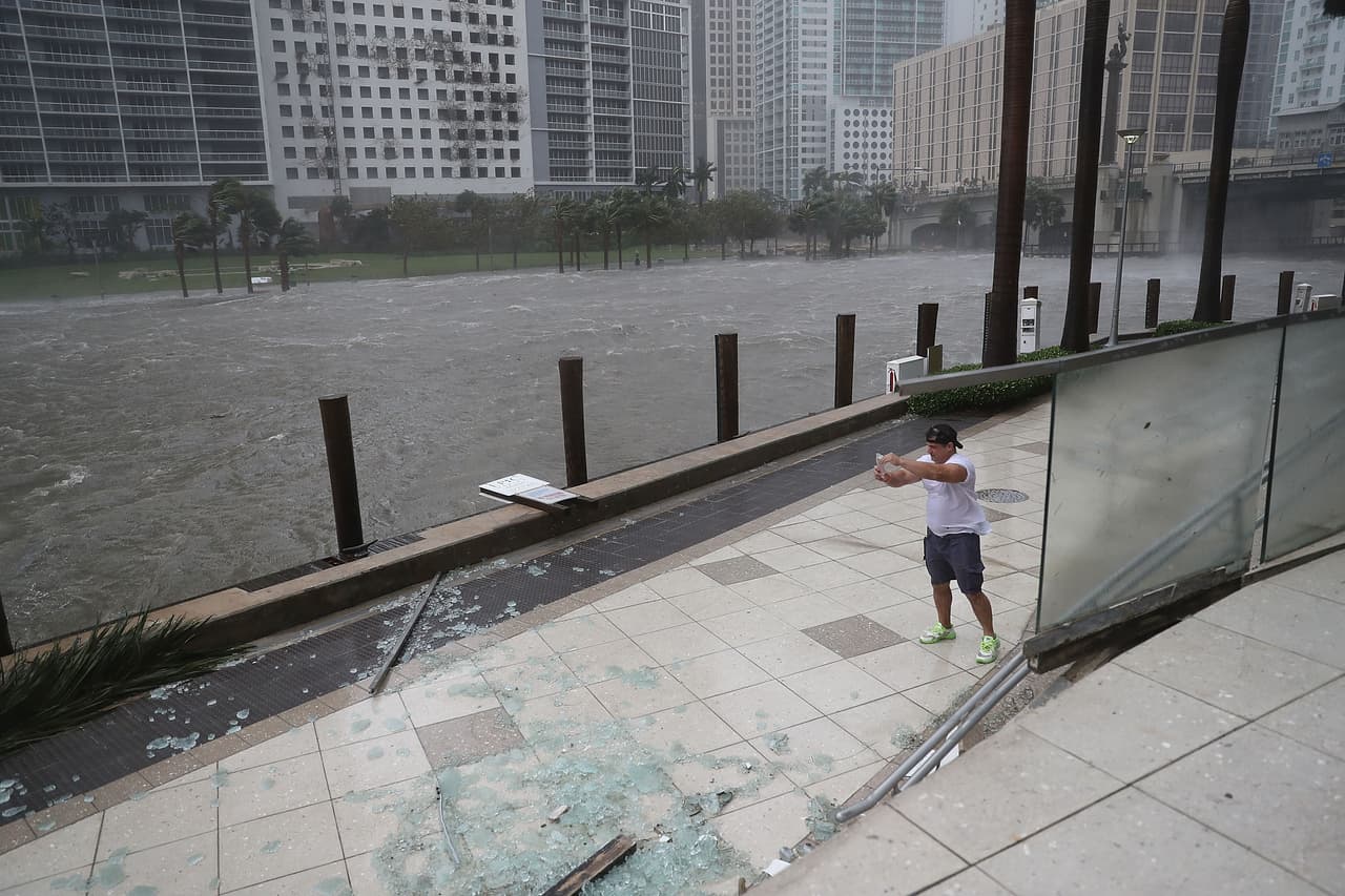 Un hombre se toma una selfie al lado del río Miami, en el centro de la ciudad. Hubo vidrios rotos, puertas y ventanas destrozadas, a pesar de ser cristales de impacto.