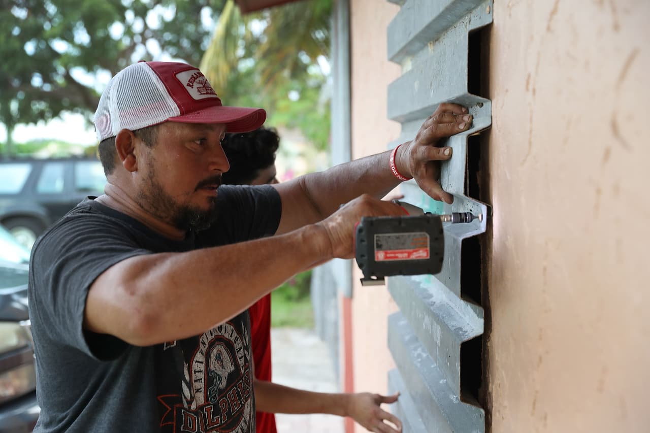 Un residente de Homestead, al sur de Florida, protege las ventanas de su casa con estructuras antihuracanes.