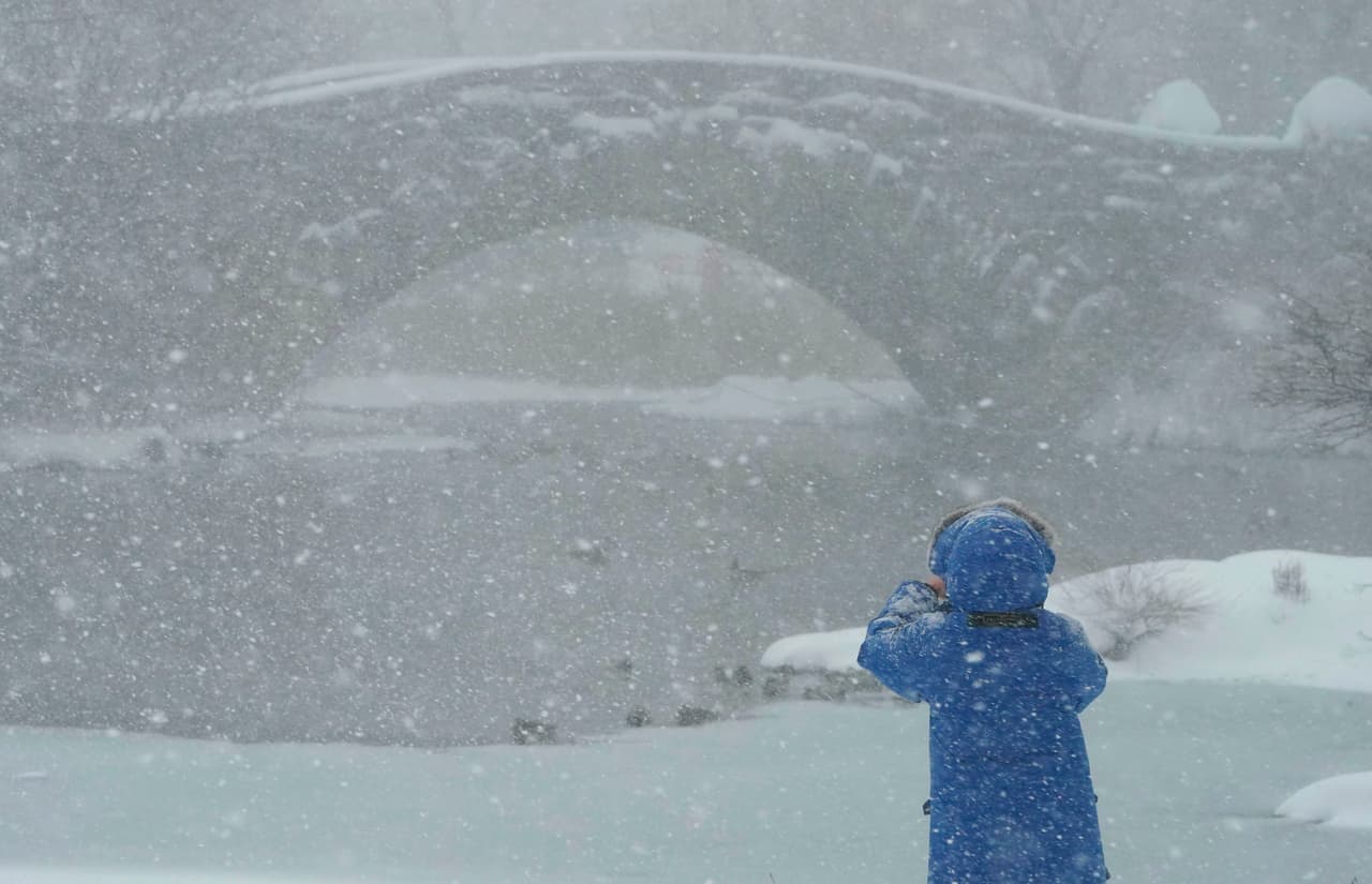 Una mujer camina cerca del puente Gapstow en Central Park.