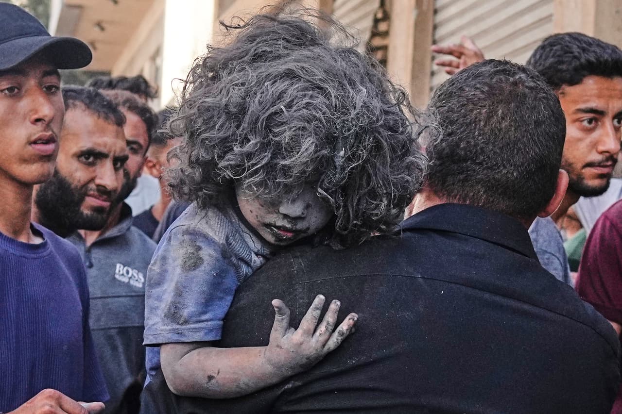 Un hombre palestino carga a un niño herido tras un ataque israelí contra un edificio residencial en la ciudad de Gaza, el viernes 27 de junio de 2025.