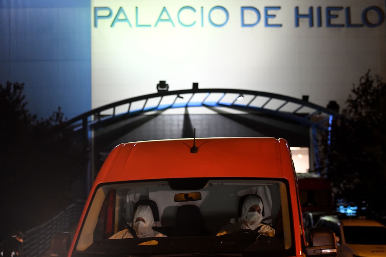 <b>La peor cara de la pandemia (23 de marzo). </b>Miembros de la Unidad de Emergencia del Ejército de España llegan al centro comercial Palacio de Hielo, de Madrid, donde una pista de patinaje sobre hielo fue convertida en una morgue temporalmente.
<br>