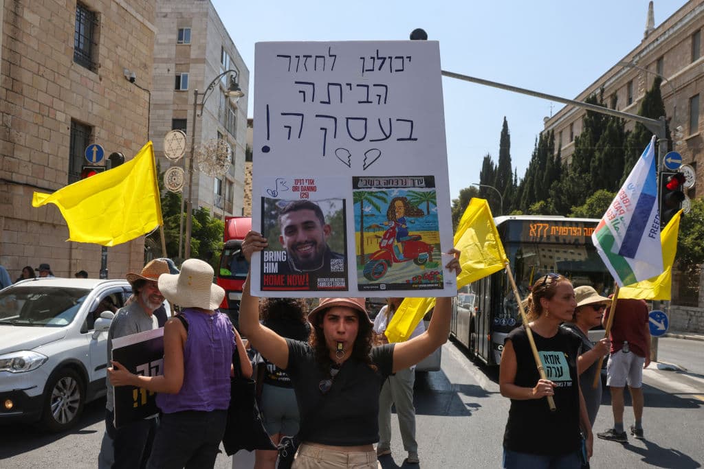 Manifestantes interrumpen el tráfico con pancartas y eslóganes exigiendo al gobierno que haga lo que tenga que hacer para traer a los rehenes de vuelta a casa.