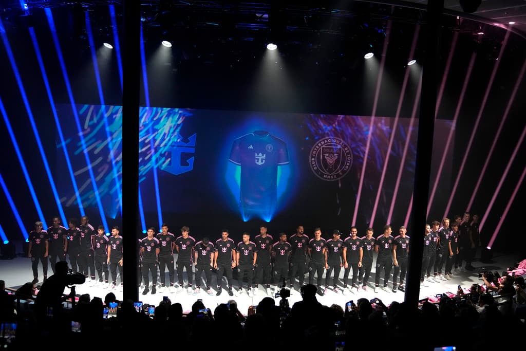 Los jugadores de fútbol del Inter Miami suben a un escenario mientras visten nuevos uniformes con el logotipo de Royal Caribbean International durante un evento en el crucero más grande del mundo.