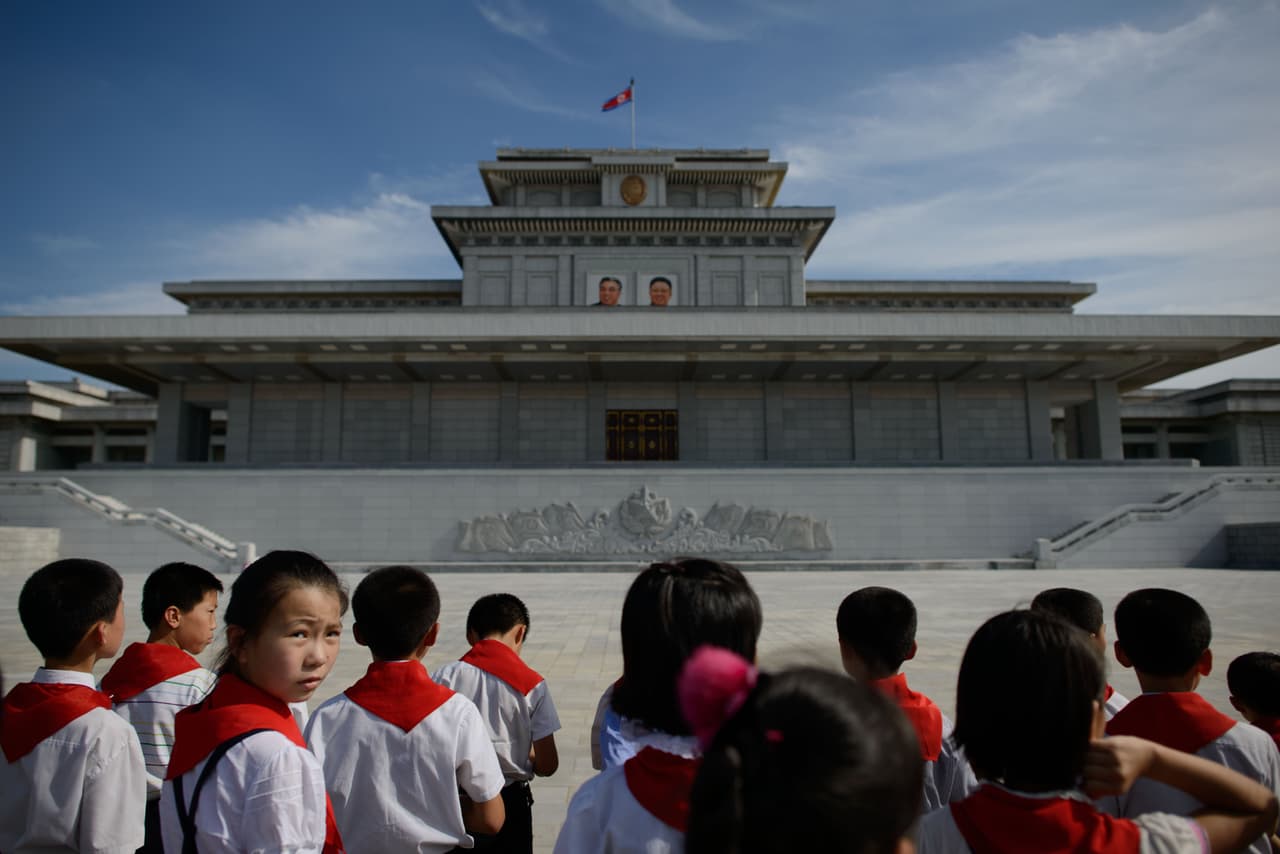 Niños de una escuela norcoreana se inclinan ante los retratos de los líderes norcoreanos Kim Il-Sung y Kim Jong-Il en el mausoleo del Palacio Kumsusan del Sol en Pyongyang. 25 de julio de 2013.