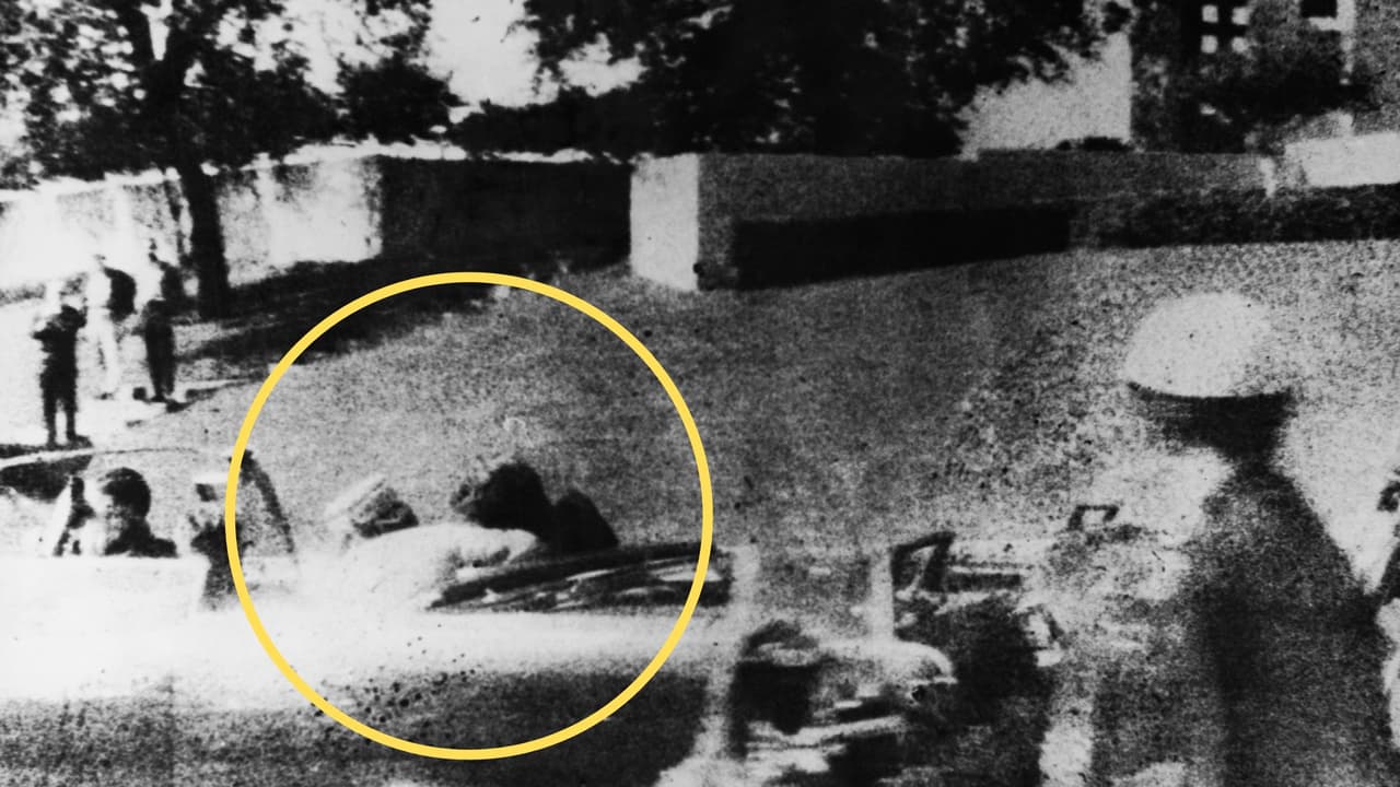 La primera dama, Jacqueline Kennedy, se inclinó para ayudar a su esposo, John F. Kennedy, justo después de que le dispararan mientras la caravana presidencial pasaba por Dealey Plaza, en Elm Street, Dallas, Texas, el 22 de noviembre de 1963.