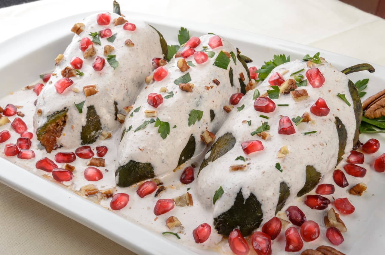 La creencia mexicana dicta que los fallecidos llegan a sustraer la esencia de los alimentos que se colocan en la ofrenda. ¿Y qué mejor para los difuntos que unos chiles en nogada?