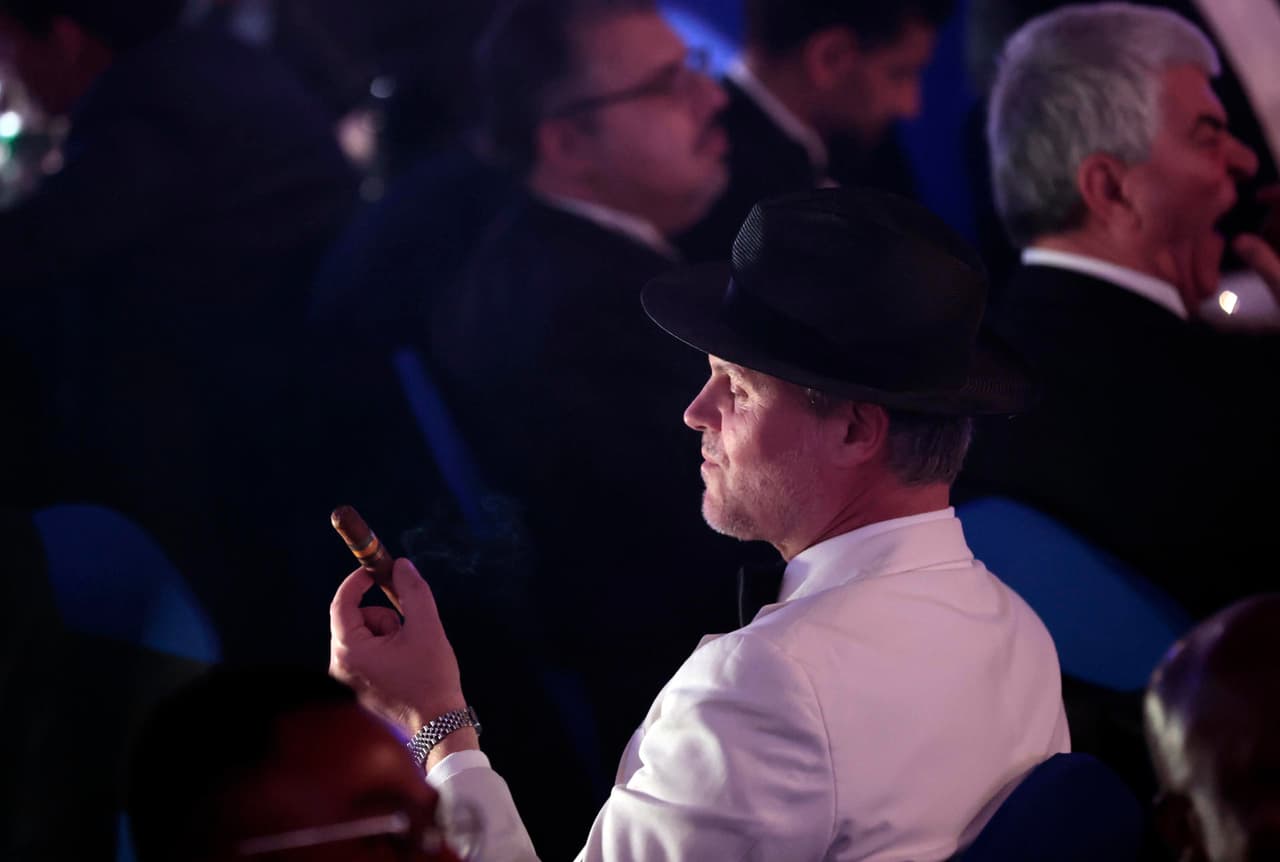 En la imagen, uno de los asistentes fuma durante la cena y subasta de humidores.