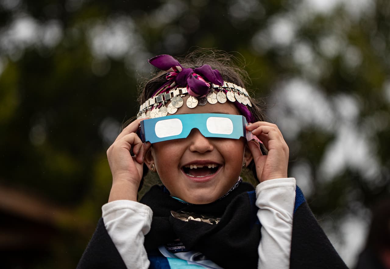 Magdalena Nahuelpan, una niña indígena mapuche, observa el eclipse solar total con lentes especiales en Carahue, Chile. El fenómeno fue visible totalmente desde Chile y la región de la Patagonia norte de Argentina, así como de forma parcial en Bolivia, Brasil, Ecuador, Paraguay, Perú y Uruguay.