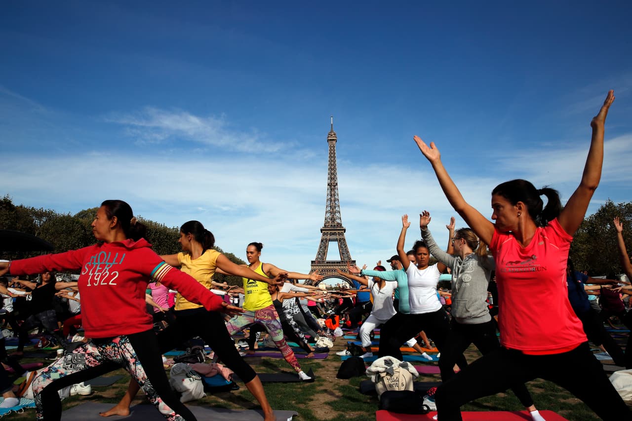 Además, tiene 2,500,000 remaches; 7,300 toneladas de hierro; 60 toneladas de pintura, y 5 ascensores. El calendario de construcción fue de 2 años, 2 meses y 5 días. El primer piso se terminó el 1 de abril de 1888 y el segundo el 14 de agosto de ese año. En la foto se ve a cientos de personas frente a la torre para un evento deportivo de práctica de yoga.