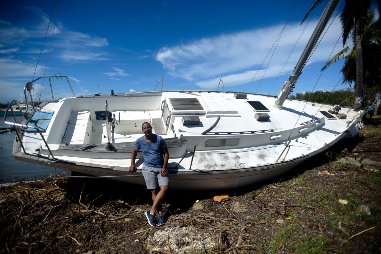 Rafael Velázquez, un residente de Cayey, posando para un retrato junto a su bote tendido en la tierra después de la marejada por el huracán María en Santa Isabel, Puerto Rico. "Lo compré hace un año y todavía no lo había usado, la tormenta me lo estrenó", dijo Velázquez.