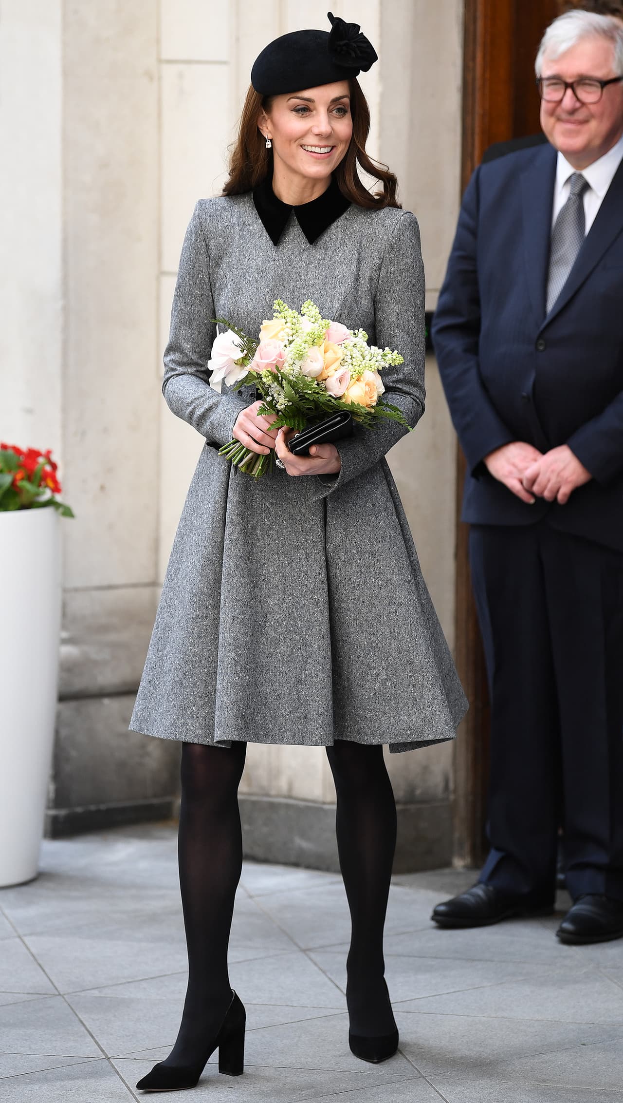 Completó su look con una cartera, tocado de Sylvia Fletcher, medias y zapatos negros, creando una apariencia más discreta para no robarle protagonismo a la reina, como marca el protocolo real.
