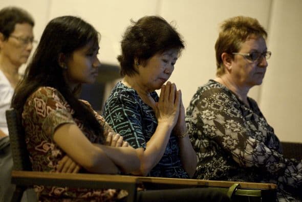 Gente reza por las víctimas del Malaysia Airlines en una iglesia cerca de Kuala Lumpur, Malasia.