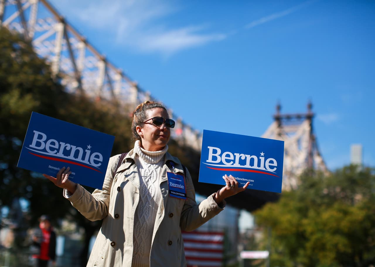 Una mujer sostiene pancartas mientras durante el mitin de campaña para Sanders.