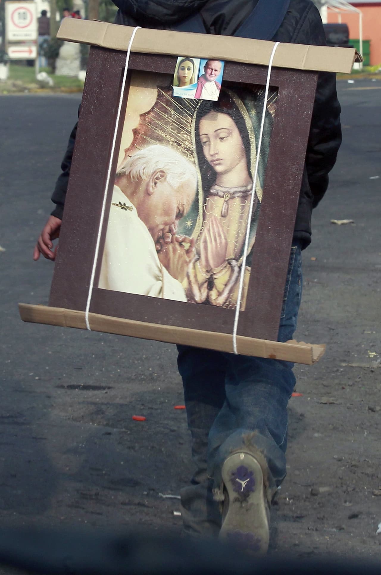Un peregrino sostiene un cuadro de la también llamada La Guadalupana con Juan Pablo II, muy querido en México.