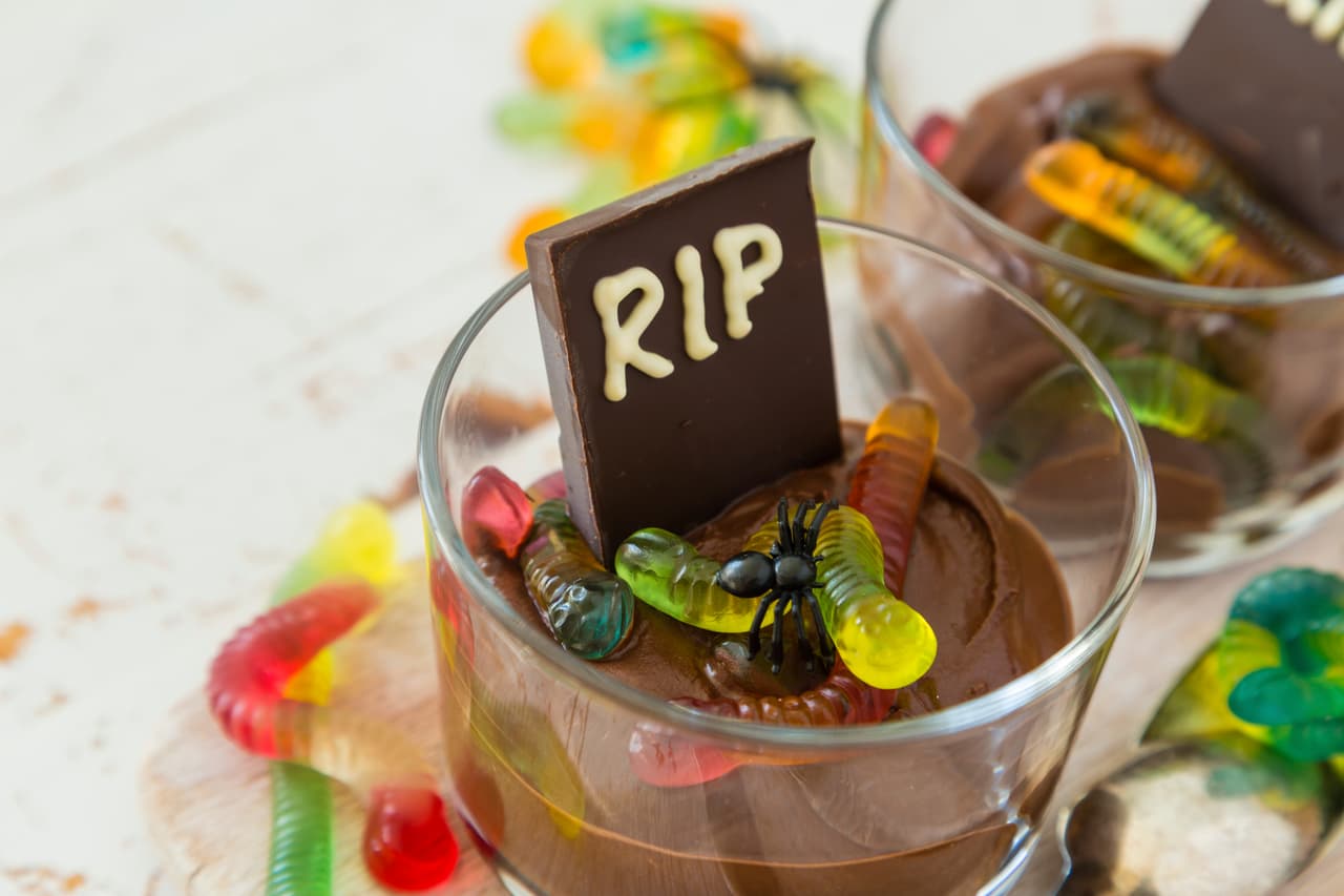 <b>Tumbas de mousse de chocolate</b>
<br>Hacer mousse de chocolate es muy sencillo: necesitas derretir (a baño maría o en el microondas) una tableta del
<b><a href="http://www.univision.com/temas/chocolate">chocolate </a></b>de tu preferencia, mantequilla y azúcar. Mezcla y deja enfriar. Por separado bate las claras de cuatro huevos hasta que queden a punto de nieve. En un bowl mezcla las yemas del huevo con el chocolate y agrega las claras batidas. Vierte en moldes individuales, enfría y sirve con gomas en forma de gusanos.