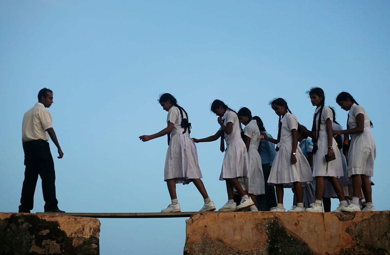 <b>Sri Lanka. </b>Niñas de una escuela primaria caminan a través de un tablón en las paredes de una fortaleza antigua para llegar a sus clases. 8 de julio de 2009.