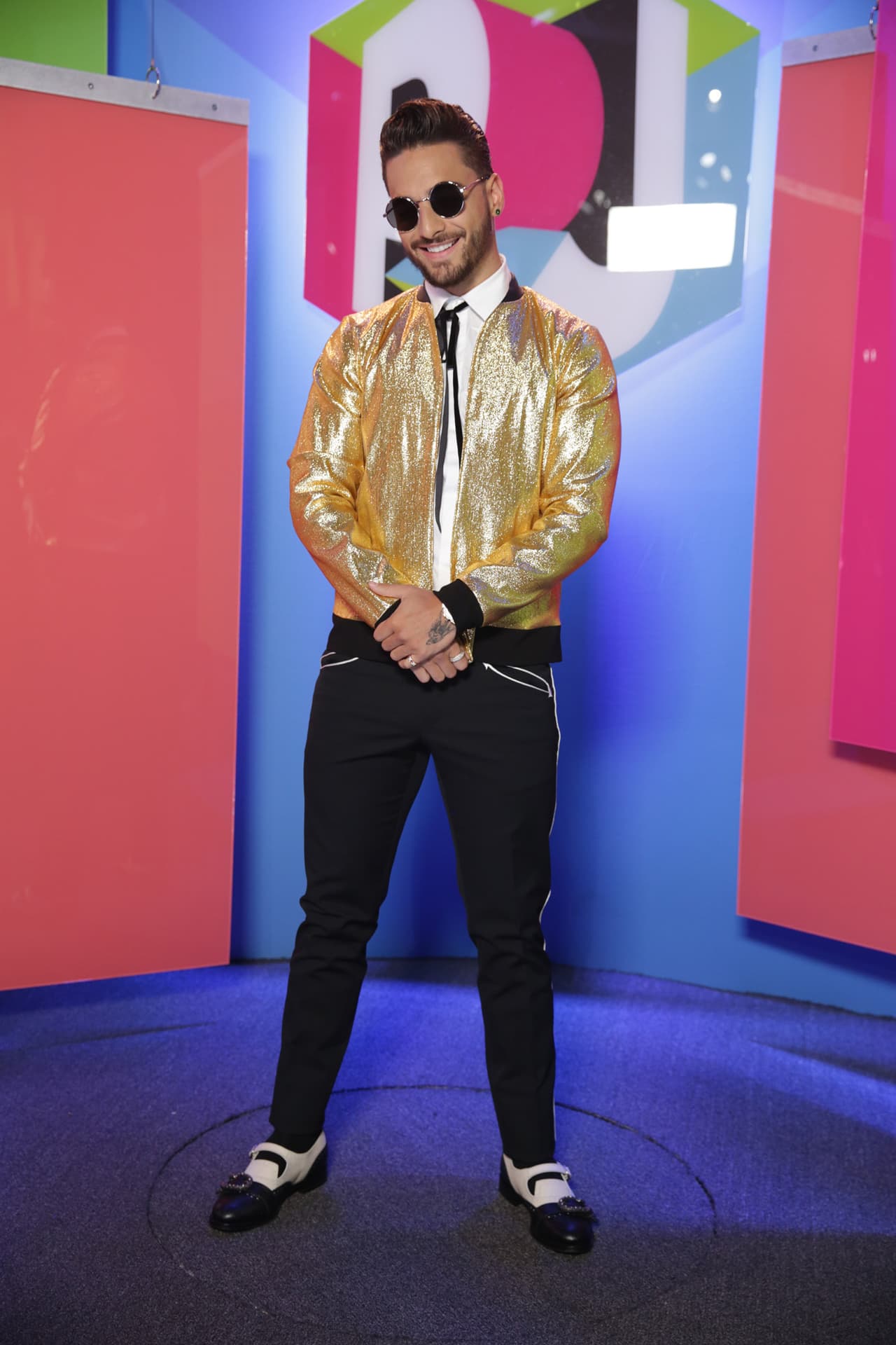 Maluma fue uno de los mejor vestidos de la noche con su cazadora bomber dorada de la marca mexicana Ocelote. El colombiano llevó un pantalón negro con ribetes matálicos, camisa abotonada y una cinta al cuello. Una combinación perfecta entre elegancia y bling bling.