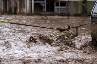 Este hombre se aferra a una cuerda para cruzar la calle tras el desbordamiento del río Copiapó, una de las impactantes imágenes de Chile esta semana.