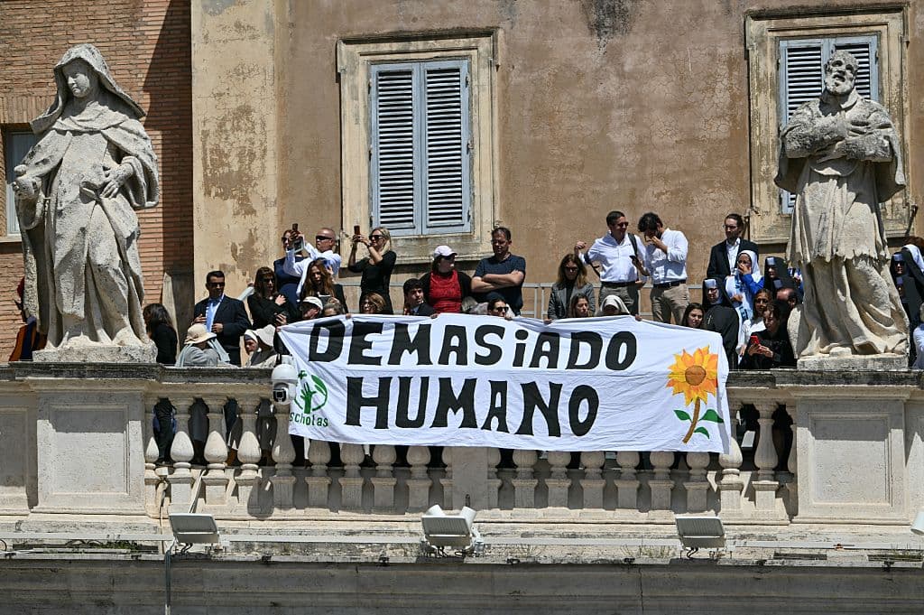 <h3 class="cms-H3-H3">"Demasiado humano"</h3>
<br>
<br>Miembros del público sostienen una pancarta durante el funeral del papa Francisco en la Plaza de San Pedro, Vaticano, el 26 de abril de 2025.
<br> 
<br>