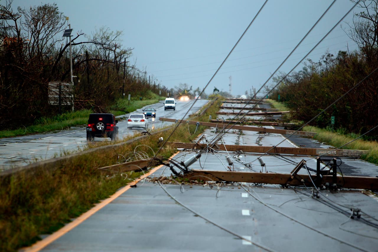Postes de una línea eléctrica derribados sobre una autopista de Luquillo. Autoridades anunciaron que 
<b>Puerto Rico se quedó 100% sin electricidad. </b>