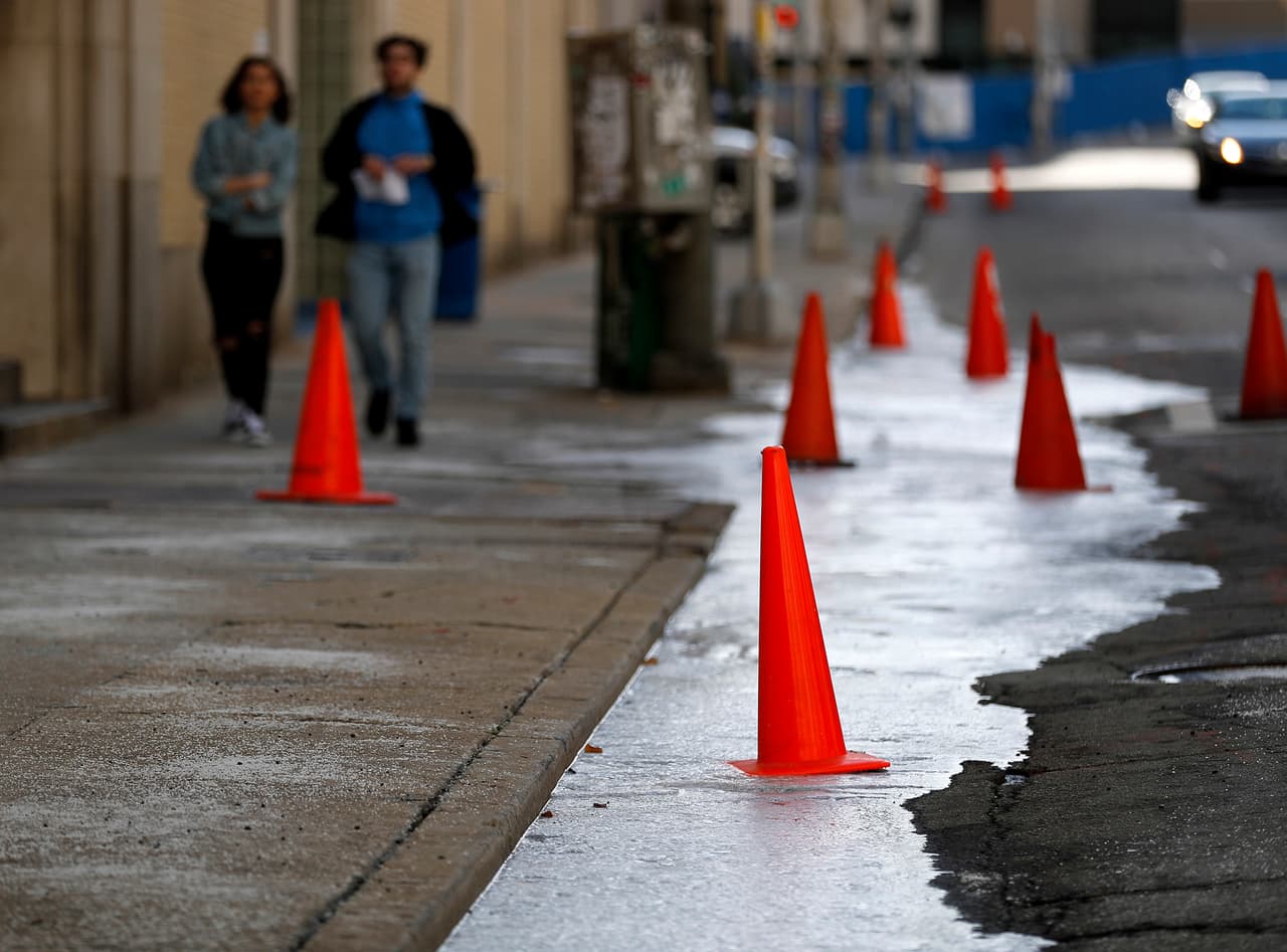 Conos de precaución fueron colocados en una acera en una calle de Atlanta para advertir la presencia de hielo y el riesgo de caídas.