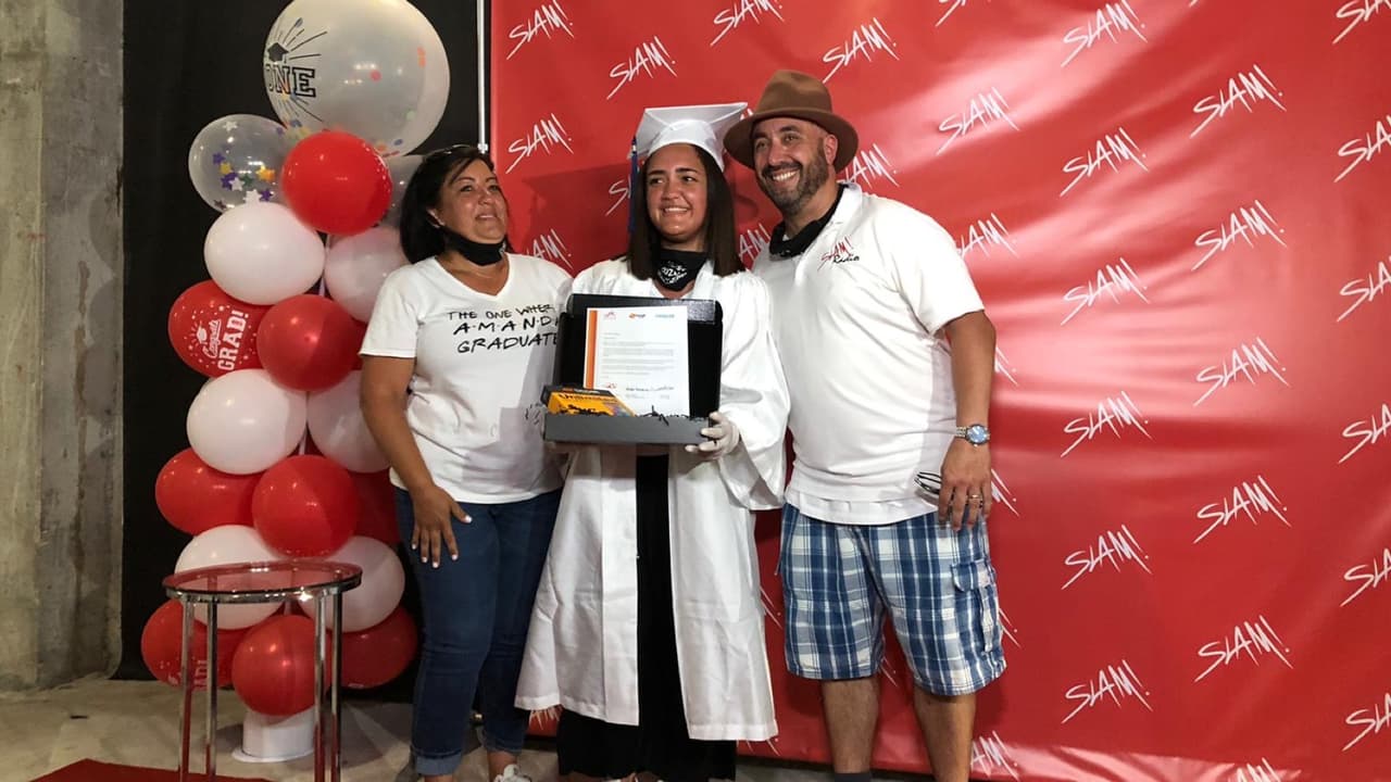 Los jóvenes se vistieron con toga y birrete para participar en la caravana que pasaba por el estacionamiento de la secundaria SLAM.