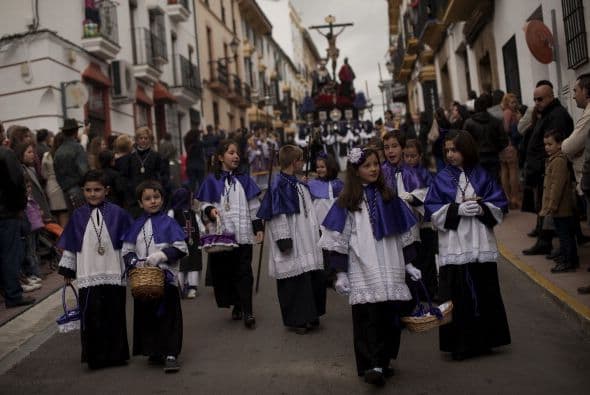Otros niños participan en las celebraciones de Semana Santa, como estos pequeños españoles.
