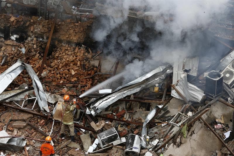Bomberos tratan de apagar los efectos de la explosión.