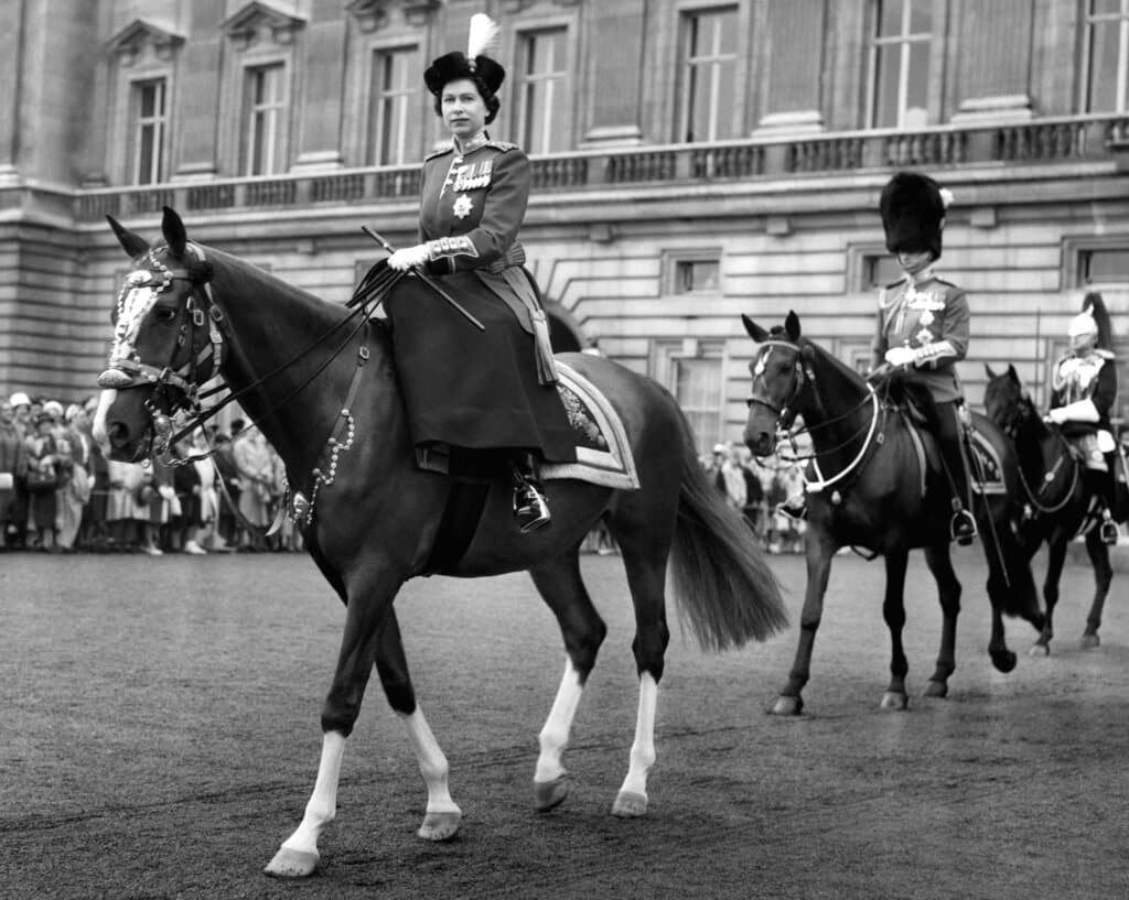 Una de sus grandes aficiones ha sido montar a caballo. En la imagen, tomada el 15 de junio de 1960, se ve a la reina cabalgando, seguida por Felipe, saliendo del Palacio de Buckingham, en Londres, para recibir el saludo en una ceremonia.