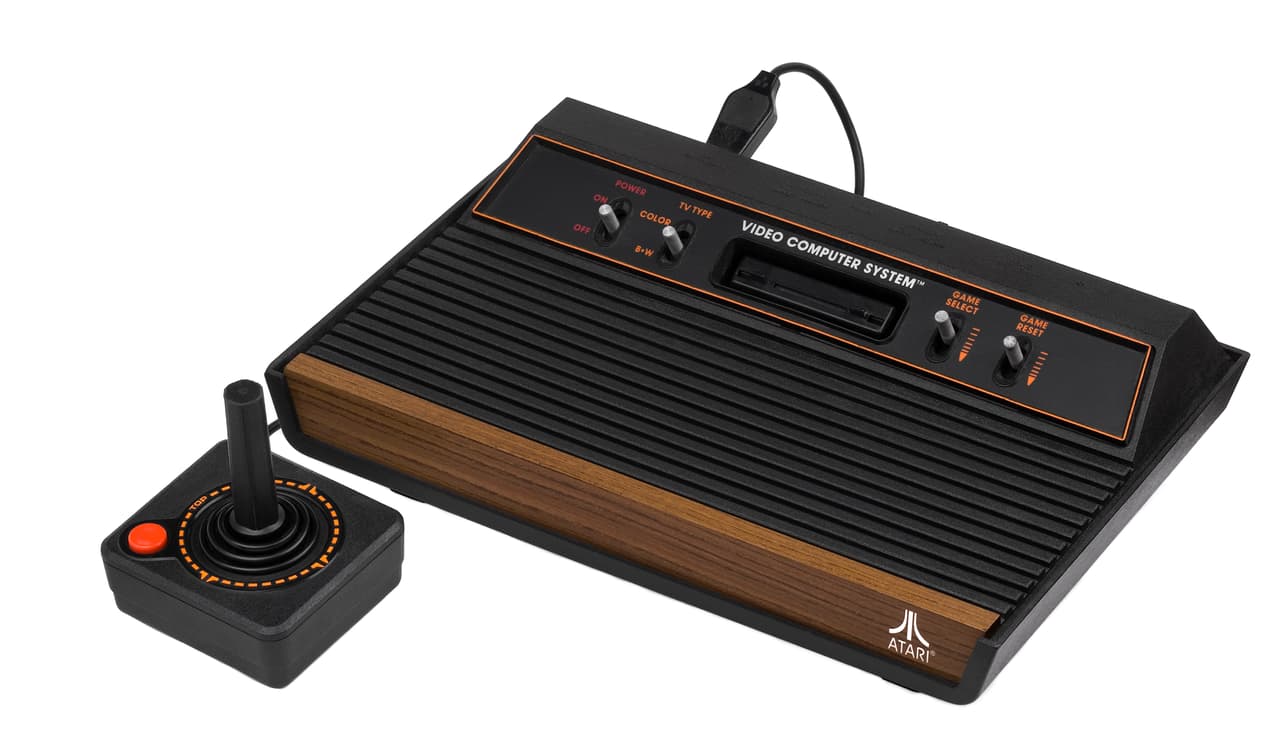 <b>Atari 2600.</b> La pequeña palanca y el botón rojo del
<i>joystick</i>, un nuevo instrumento en las manos de los jóvenes de todo el mundo, controlaba los grandes pixeles que la clásica consola negra enviaba a los televisores de la década de 1970. Atari fue una de las pioneras en la programación y fabricación de programas y dispositivos para videojuegos. Eran los primeros días de una industria que hoy genera miles de millones de dólares.