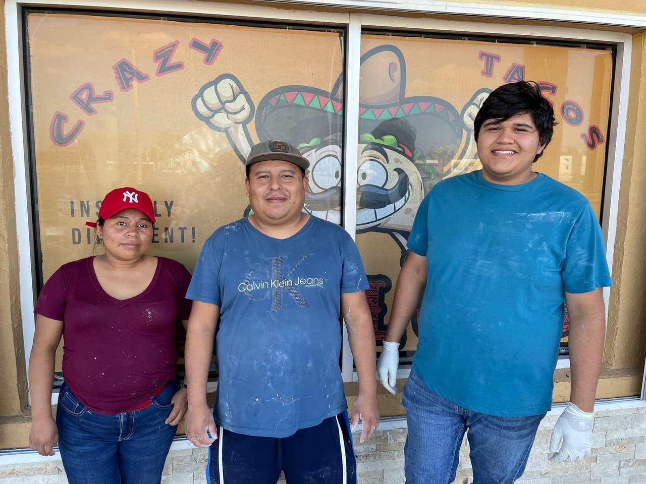 The staff at Hidalgo Crazy Tacos take a break from ceaning up after Hurricane Ian. They hope to reopen within a month. Left to right: Kitchen worker, Juana Tojil, chef Manuel Tojin, and manager Juan Perez.