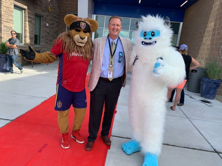 El superintendente del distrito escolar de Canyons, Rick Robins, le dio la bienvenida a los estudiantes en 
<b>Glacier Hills Elementary</b>, en compañía de 
<i>Leo the Lion</i>, mascota del Real Salt Lake, y el yeti, 
<i>Blizzard</i>, botarga de la escuela.