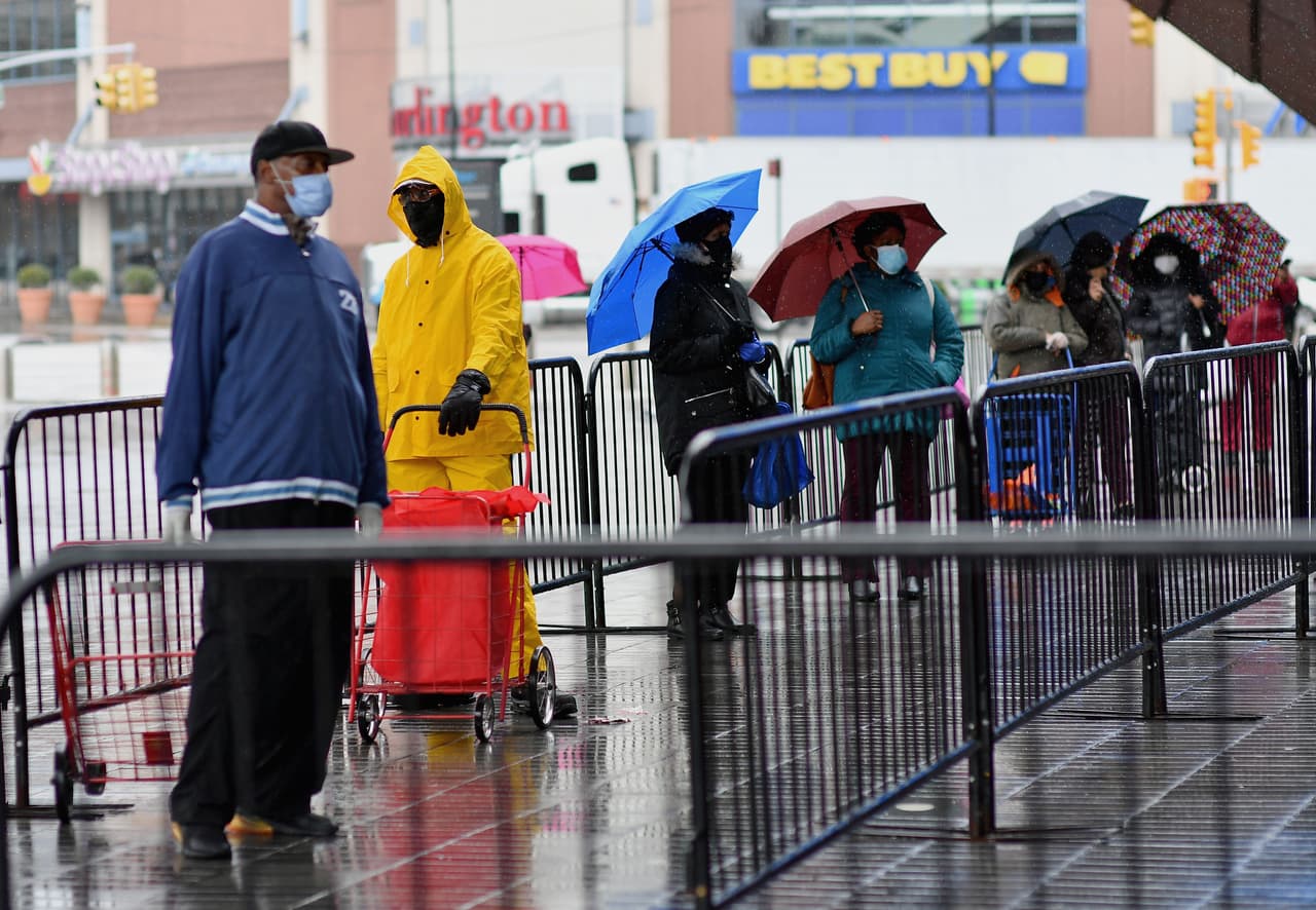 Con paraguas en mano, decenas esperan su comida gratis afuera de Barclays Cente