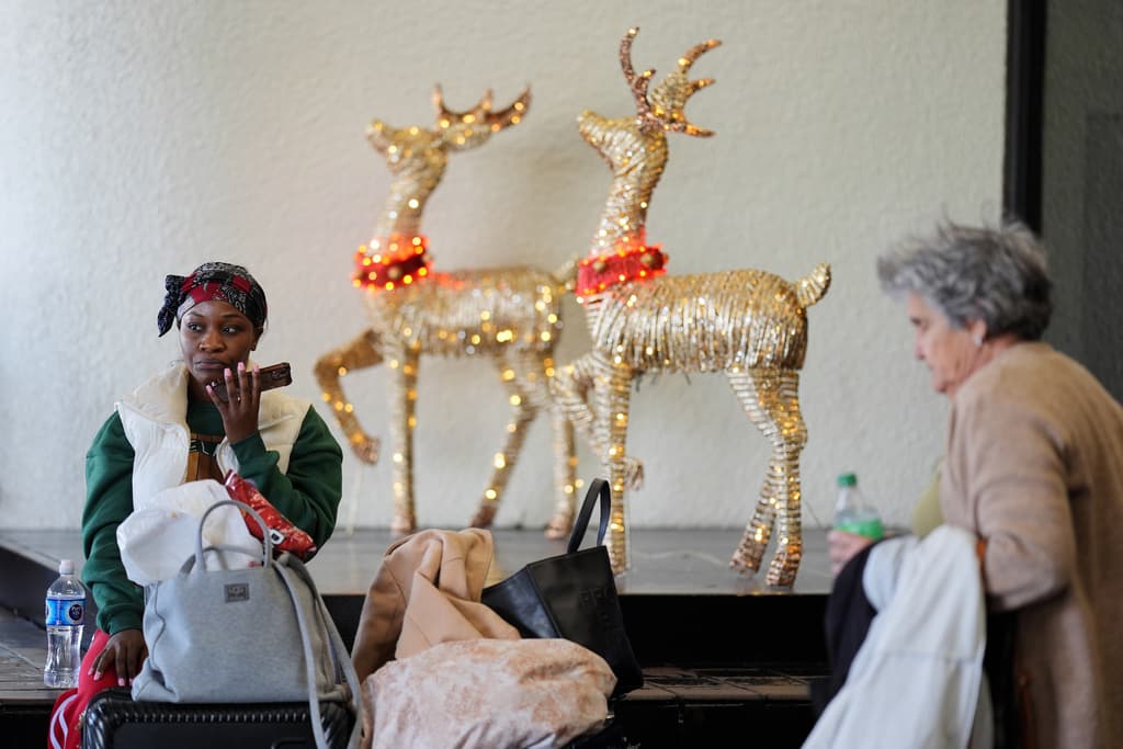 Roberta Wea espera sentada cerca de unos renos de Santa Claus.