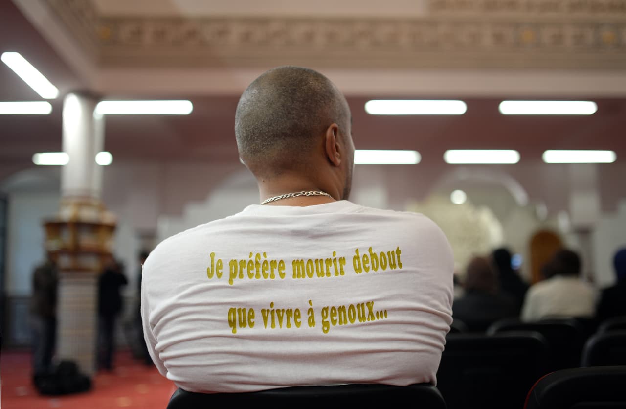 Un hombre que lleva una camiseta con la inscripción: "Prefiero morir de pie que vivir de rodillas" es un representante que firmó un texto contra el terrorismo.
